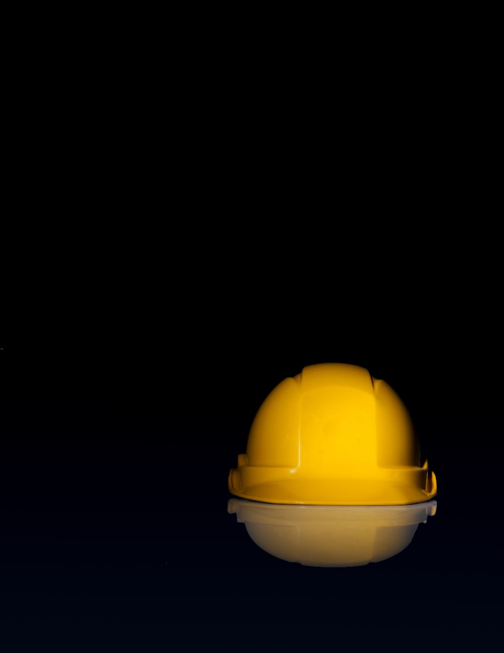A hard hat placed on a dark, shiny surface.